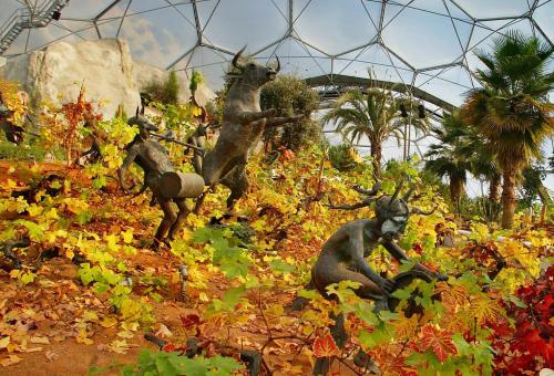 Sculptures of bull and people among grapevines in Mediterranean Biome